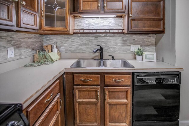 kitchen featuring dishwasher, light countertops, tasteful backsplash, and a sink