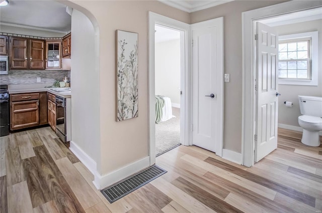 interior space with vanity, wood finished floors, visible vents, toilet, and tasteful backsplash