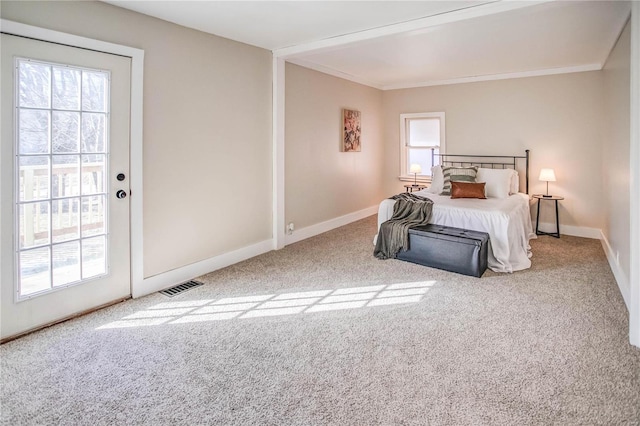 carpeted bedroom with visible vents, baseboards, and crown molding