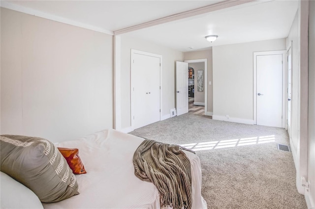 carpeted bedroom featuring visible vents and baseboards