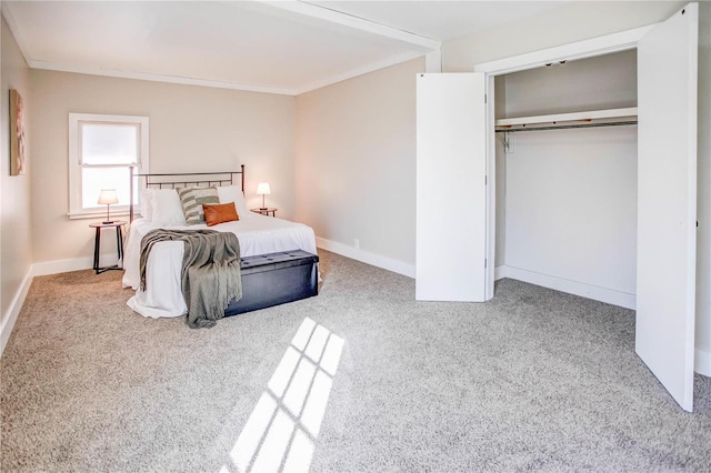 carpeted bedroom featuring a closet, baseboards, and ornamental molding