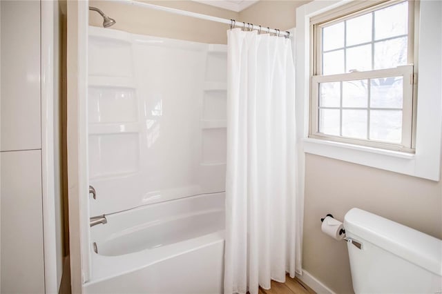 bathroom featuring toilet and shower / tub combo with curtain