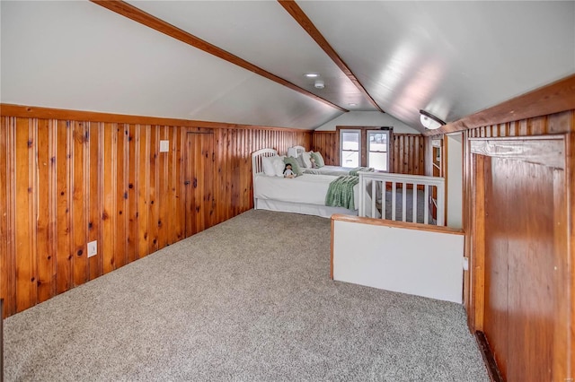 unfurnished bedroom featuring vaulted ceiling, wooden walls, and carpet