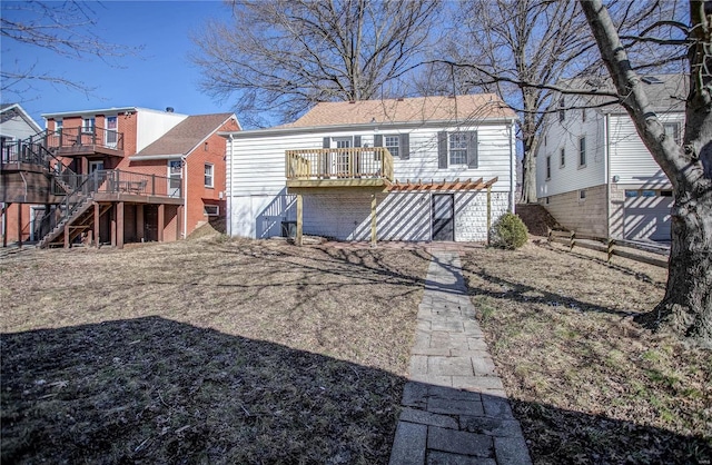 rear view of property with stairway and a wooden deck