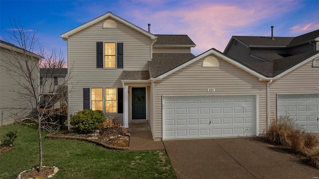 traditional-style home with a yard, concrete driveway, and a garage