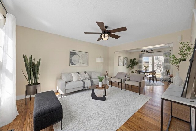living area featuring a ceiling fan and wood finished floors