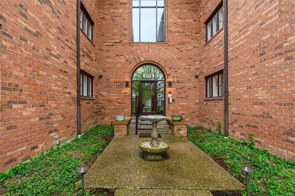 view of exterior entry featuring brick siding