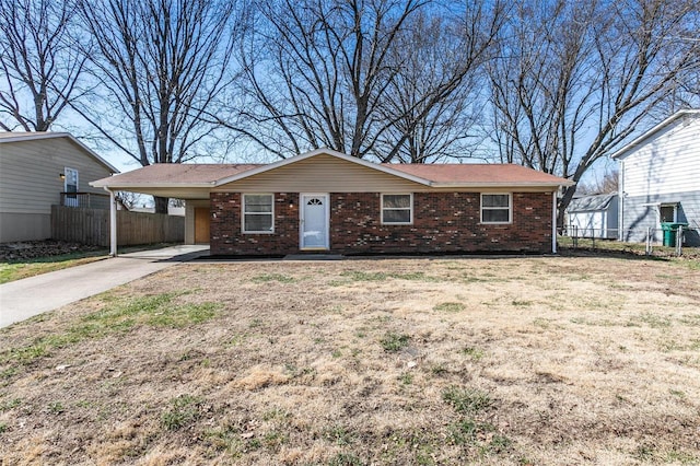 ranch-style home featuring fence, driveway, a carport, a front lawn, and brick siding