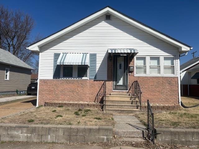 bungalow-style house with brick siding