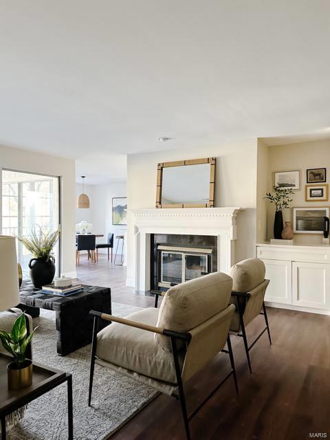 living room with wood finished floors and a glass covered fireplace