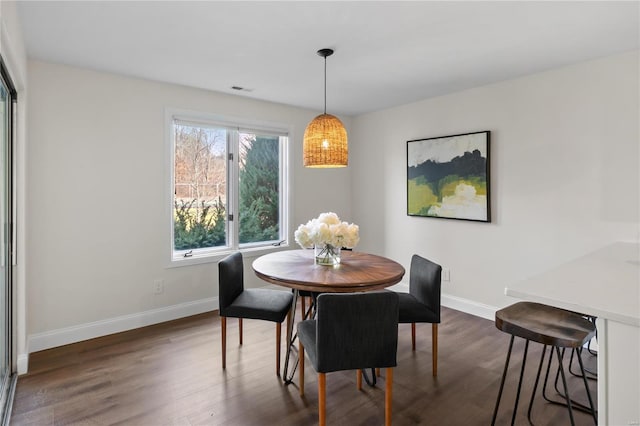 dining space with visible vents, dark wood-type flooring, and baseboards