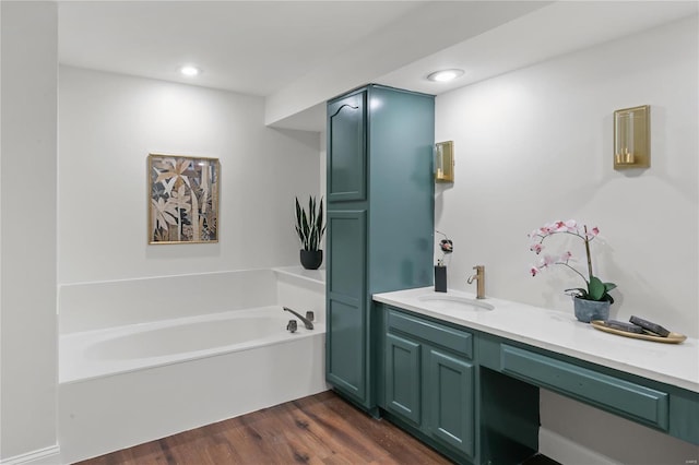 full bathroom featuring vanity, a garden tub, recessed lighting, and wood finished floors