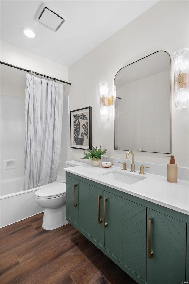 bathroom featuring visible vents, shower / bath combo with shower curtain, toilet, wood finished floors, and vanity