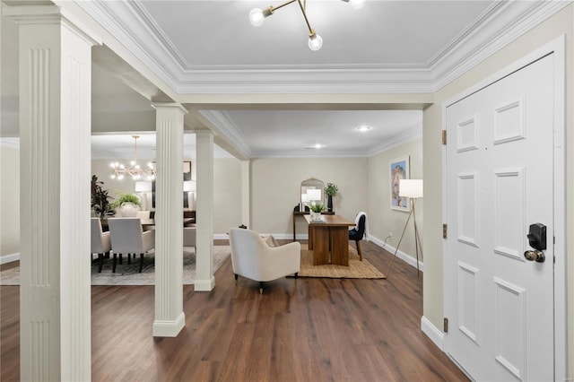 foyer featuring crown molding, decorative columns, dark wood-style flooring, and a chandelier