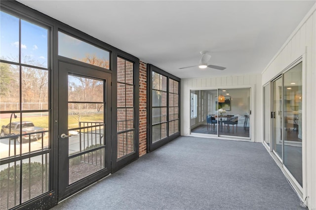 unfurnished sunroom with ceiling fan