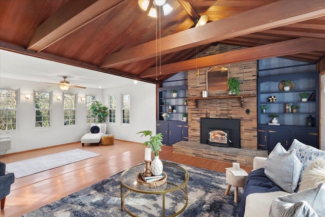 living area with vaulted ceiling with beams, baseboards, built in features, wood finished floors, and a ceiling fan