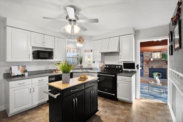 kitchen with black appliances, dark cabinets, and white cabinetry