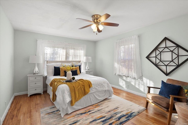 bedroom featuring ceiling fan, baseboards, and wood finished floors