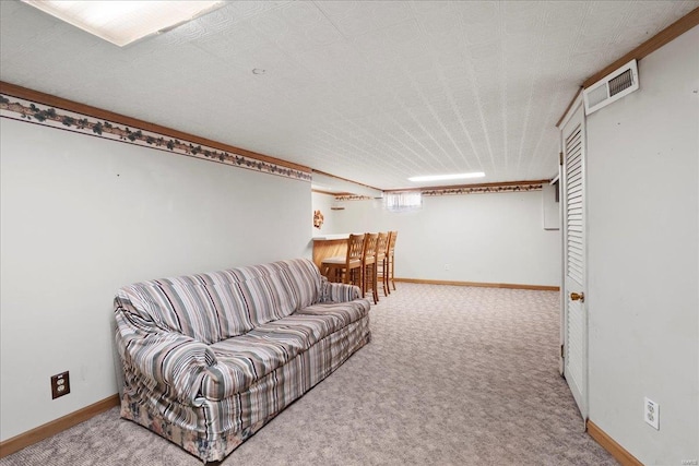 living area featuring visible vents, baseboards, and carpet