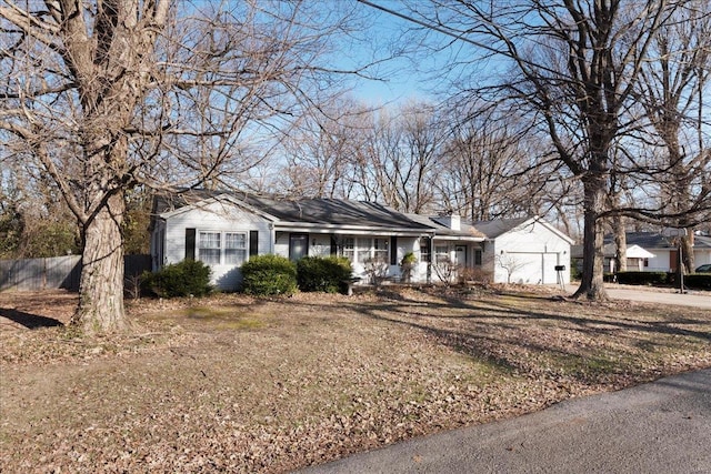 ranch-style house with an attached garage, fence, driveway, and a chimney