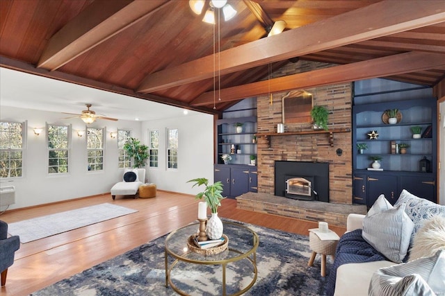 living area featuring built in features, a healthy amount of sunlight, wood finished floors, and a ceiling fan