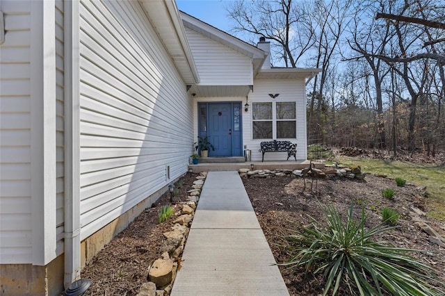 view of exterior entry with a chimney