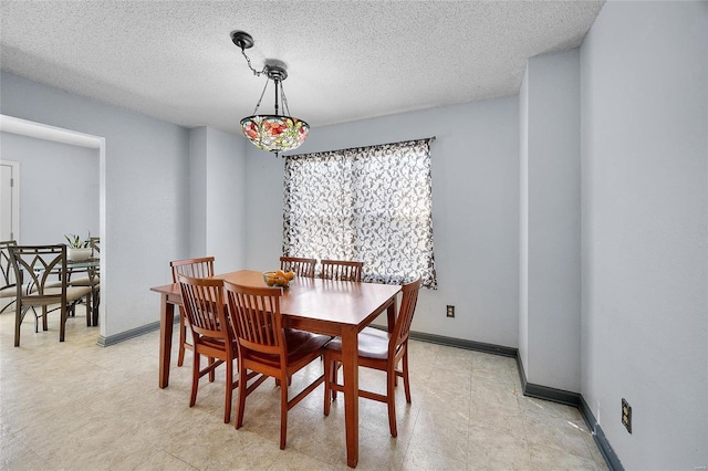 dining area featuring a textured ceiling and baseboards