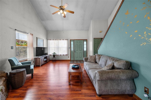 living area with high vaulted ceiling, plenty of natural light, ceiling fan, and wood finished floors