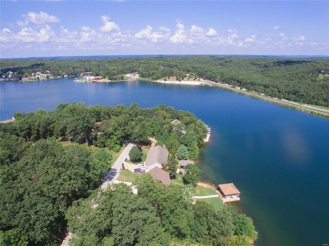 drone / aerial view featuring a wooded view and a water view