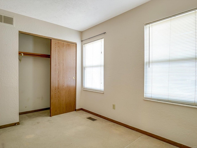 unfurnished bedroom featuring visible vents, baseboards, and a closet