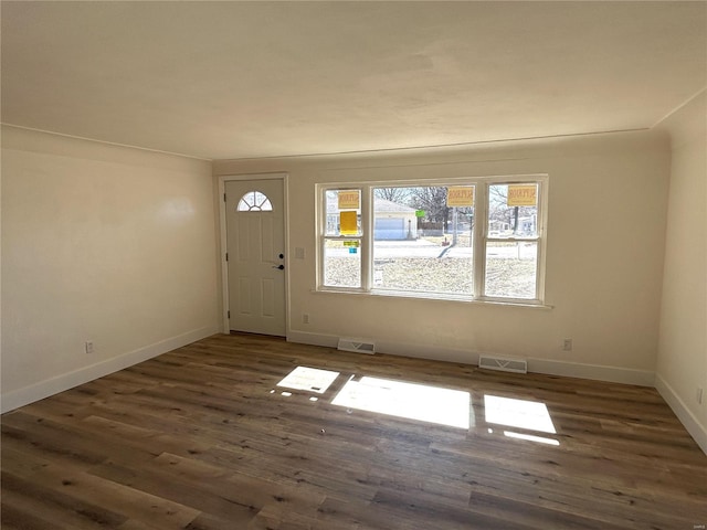 foyer featuring visible vents, baseboards, and wood finished floors