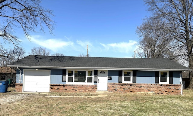 ranch-style home featuring driveway, roof with shingles, a front yard, a garage, and brick siding