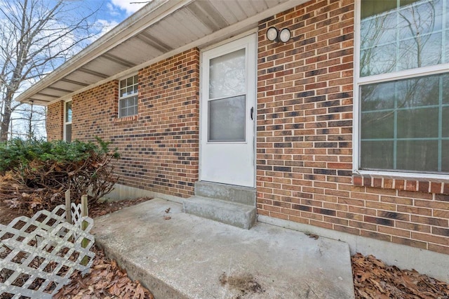 doorway to property featuring brick siding