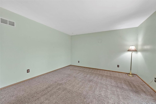 empty room featuring visible vents, baseboards, and carpet floors