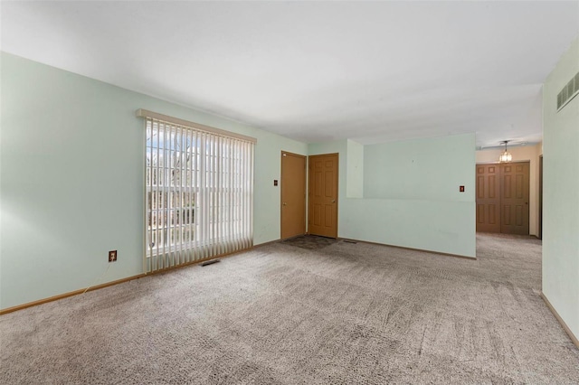 spare room with visible vents, baseboards, and carpet flooring