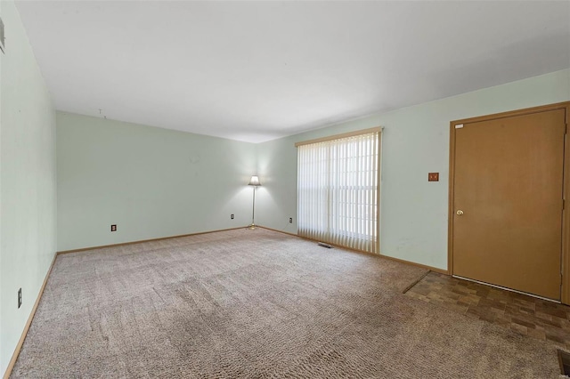empty room featuring visible vents and carpet floors
