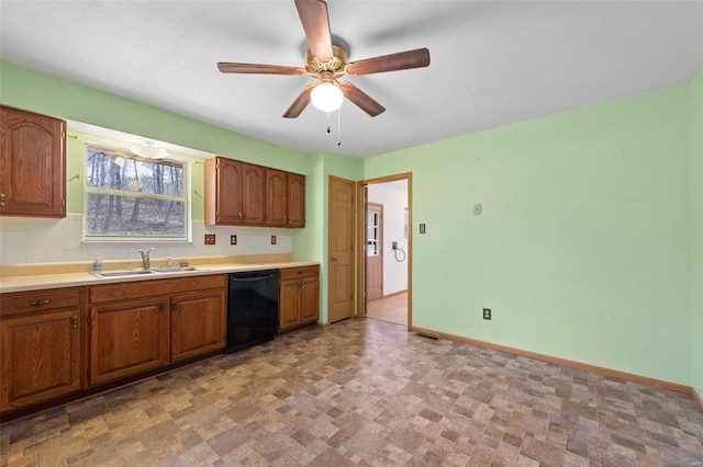 kitchen with dishwasher, brown cabinetry, baseboards, and a sink