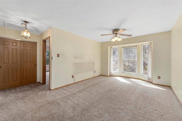 carpeted spare room with baseboards and a ceiling fan