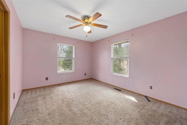 spare room with carpet flooring, visible vents, baseboards, and ceiling fan