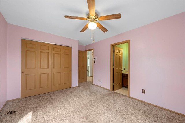 unfurnished bedroom with ensuite bath, a closet, carpet, baseboards, and ceiling fan