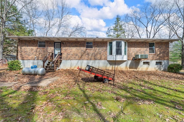rear view of property featuring brick siding, central air condition unit, and entry steps