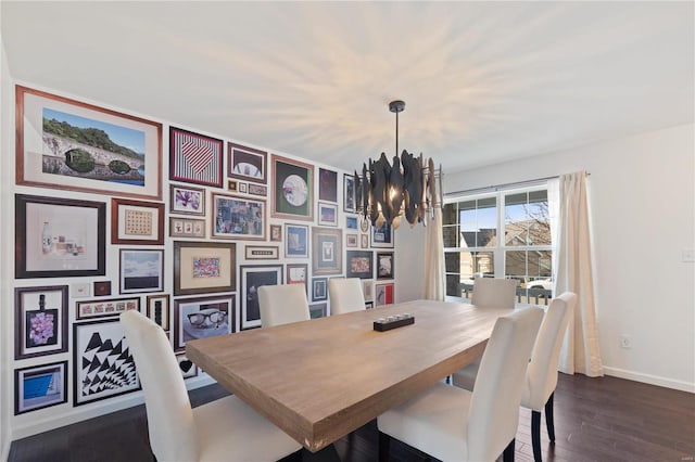 dining space with baseboards, a chandelier, and dark wood finished floors