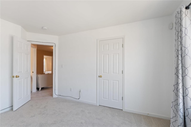 unfurnished bedroom with baseboards and carpet flooring