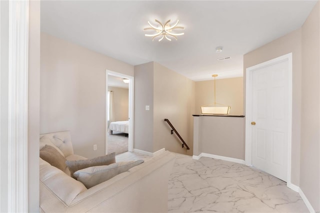 interior space featuring baseboards, an upstairs landing, marble finish floor, and visible vents