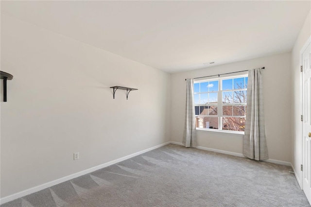 carpeted empty room featuring baseboards