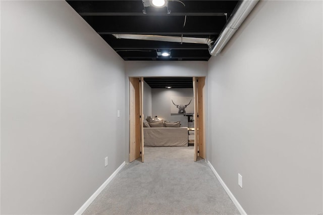 hallway with baseboards and carpet floors