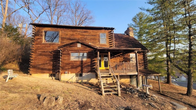 exterior space featuring a chimney, stairs, and log exterior