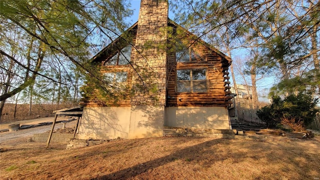 exterior space featuring log siding and a chimney