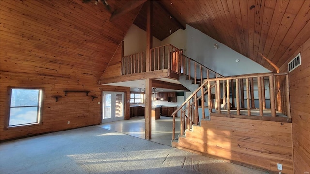 stairway featuring plenty of natural light, visible vents, wood walls, and wood ceiling