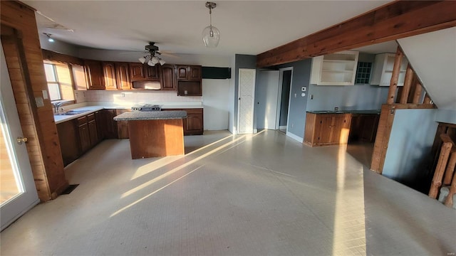 kitchen with range hood, a ceiling fan, a center island, beam ceiling, and stove
